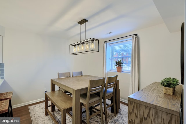 dining room featuring visible vents, baseboards, and wood finished floors