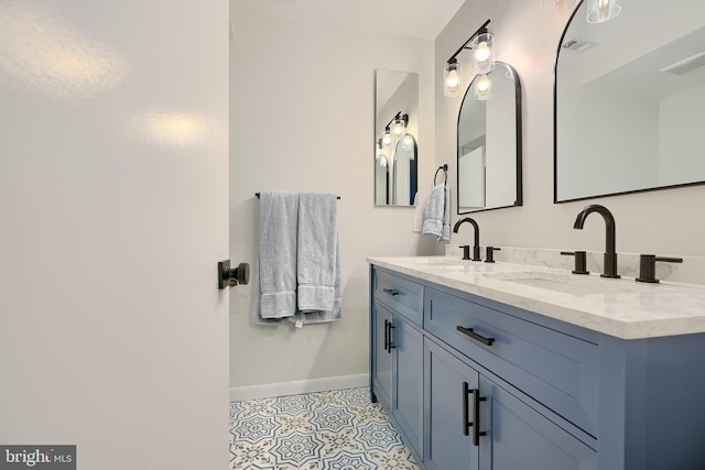 bathroom with a sink, visible vents, baseboards, and double vanity