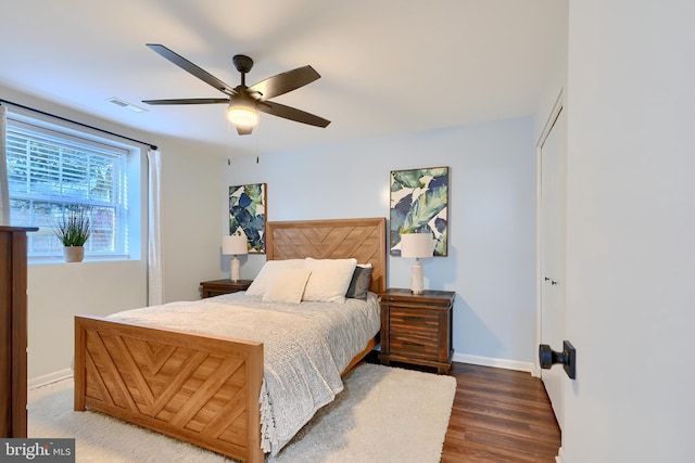 bedroom with visible vents, wood finished floors, a closet, baseboards, and ceiling fan