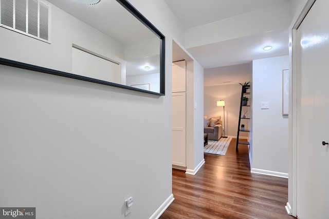 corridor with visible vents, baseboards, and wood finished floors