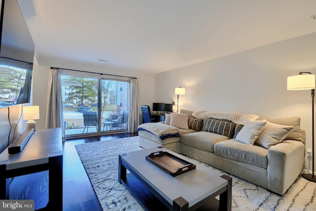 living area featuring visible vents and wood finished floors