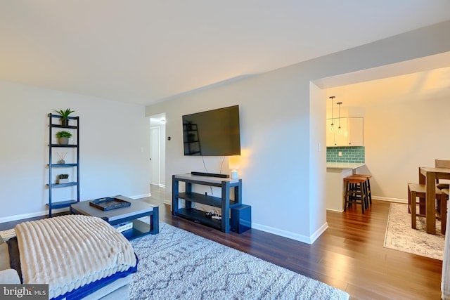 living area with baseboards and wood finished floors