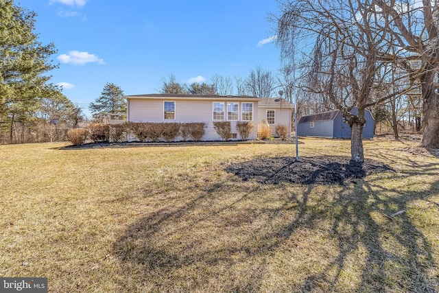 single story home with a storage shed, an outdoor structure, and a front lawn