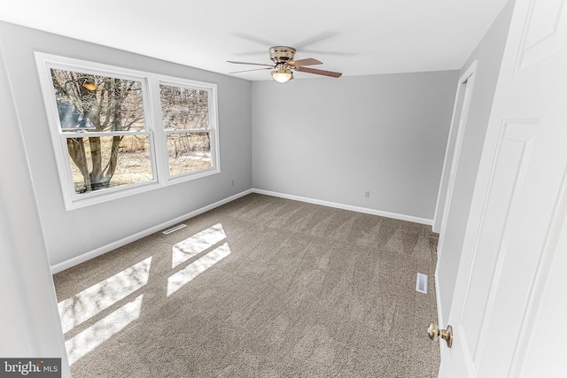 spare room with visible vents, baseboards, and carpet