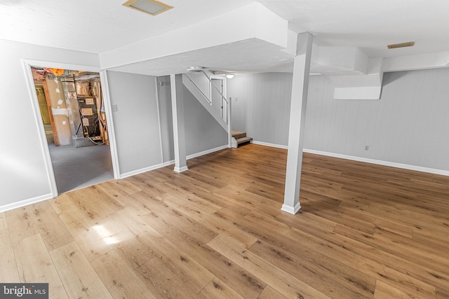 finished basement with stairway, baseboards, and hardwood / wood-style floors