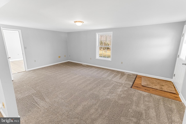 spare room featuring baseboards and carpet floors