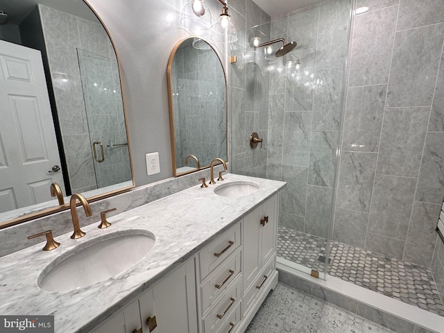 bathroom featuring a shower stall, double vanity, and a sink