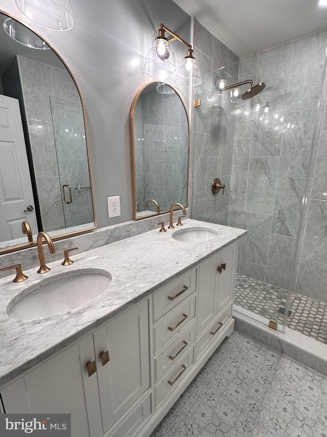 full bathroom featuring double vanity, a stall shower, and a sink