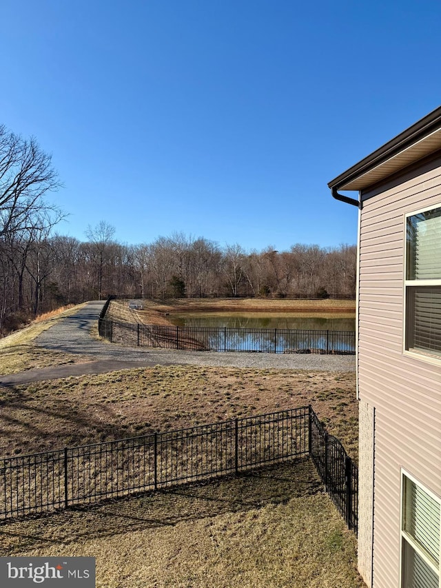 view of yard featuring fence and a water view