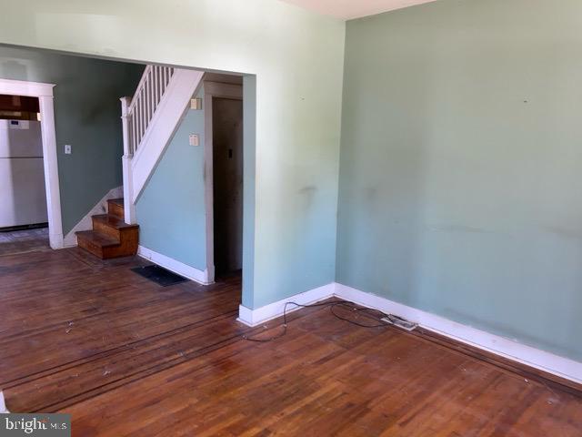 interior space featuring baseboards, wood finished floors, and stairs