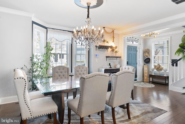 dining room with hardwood / wood-style flooring, ornamental molding, baseboards, and a chandelier