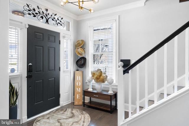 entrance foyer with stairway, plenty of natural light, wood finished floors, and ornamental molding