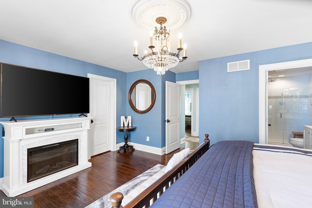 bedroom featuring a high end fireplace, visible vents, baseboards, wood finished floors, and a notable chandelier