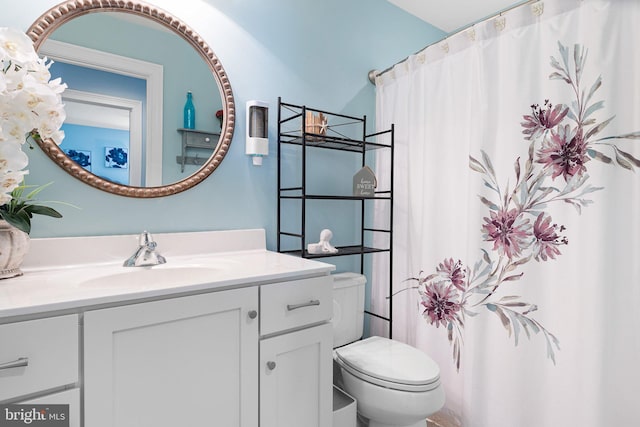 bathroom featuring a shower with shower curtain, toilet, and vanity