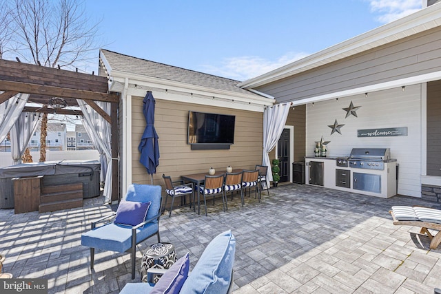 view of patio with grilling area, an outdoor kitchen, a hot tub, and a pergola