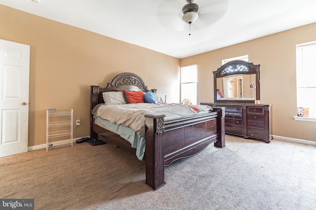 bedroom with multiple windows, a ceiling fan, baseboards, and carpet floors