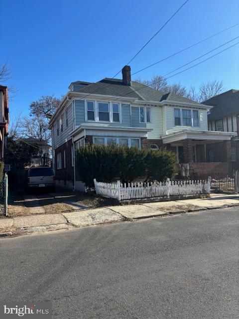 view of front of house featuring a fenced front yard and a chimney