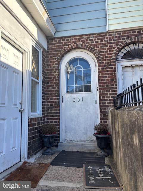 entrance to property featuring brick siding