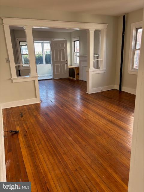 entryway featuring baseboards, plenty of natural light, and dark wood-style floors