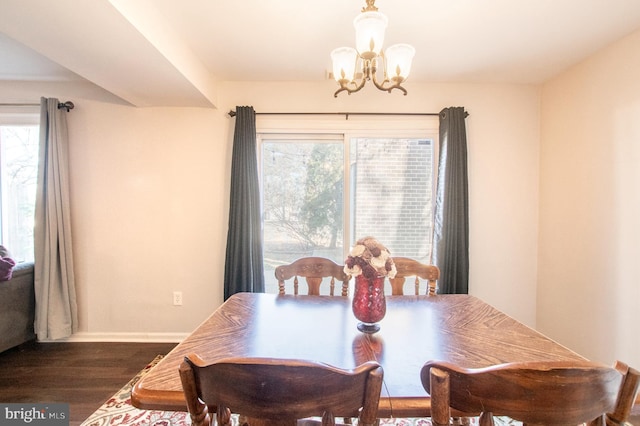 dining room featuring a wealth of natural light, baseboards, dark wood-type flooring, and a chandelier