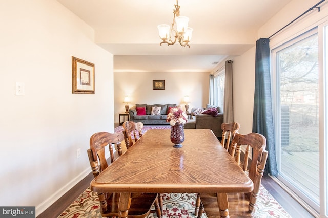 dining room featuring a chandelier, baseboards, and dark wood-style flooring