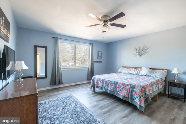 bedroom featuring wood finished floors, baseboards, and ceiling fan