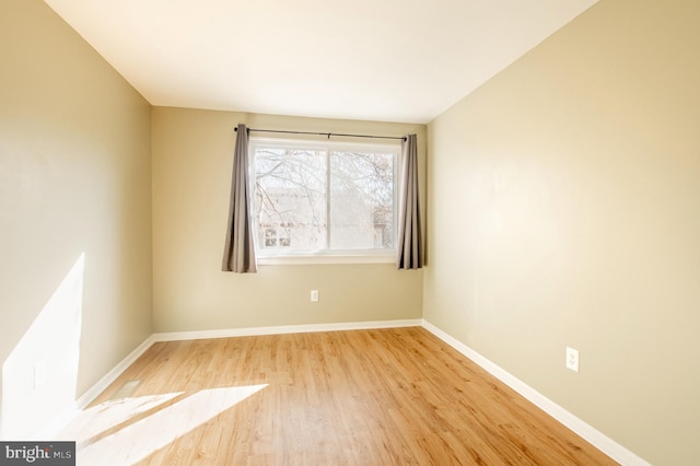 empty room featuring baseboards and wood finished floors