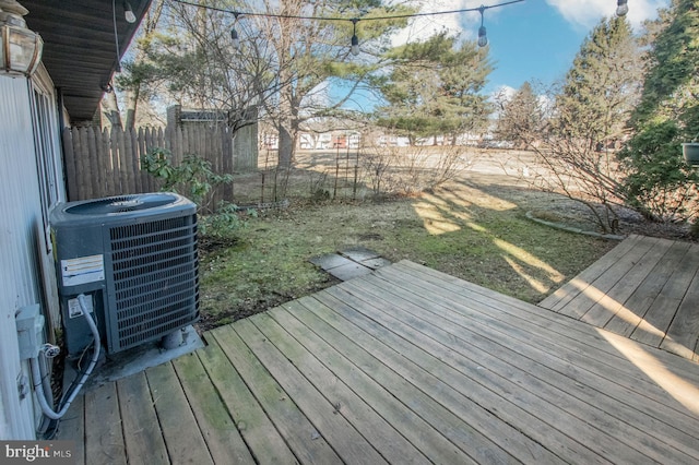 deck with central air condition unit, a yard, and fence