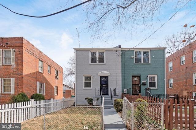 view of front of home featuring brick siding and a fenced front yard