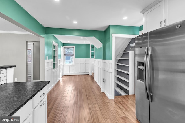 kitchen featuring light wood finished floors, stainless steel fridge with ice dispenser, recessed lighting, wainscoting, and white cabinetry