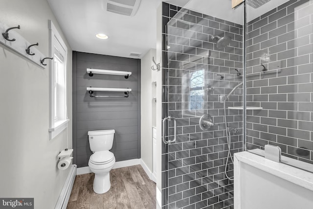 full bathroom featuring wood finished floors, visible vents, a stall shower, a baseboard heating unit, and toilet