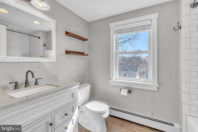 full bathroom with vanity, wood finished floors, a shower, toilet, and baseboard heating