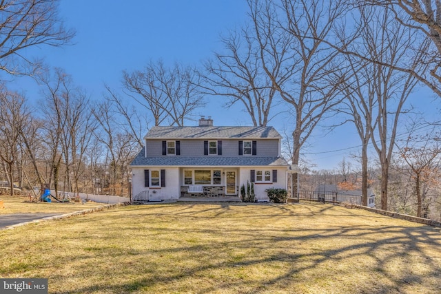 view of front of home featuring a front lawn, fence, roof with shingles, and a chimney