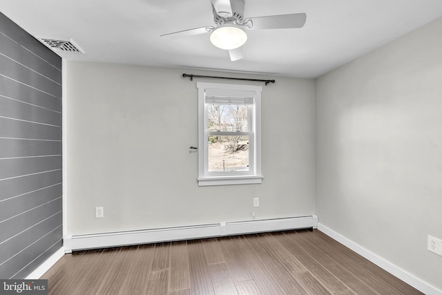 empty room with wood finished floors, baseboards, visible vents, a baseboard radiator, and ceiling fan