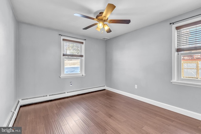 spare room featuring wood finished floors, baseboards, baseboard heating, and ceiling fan