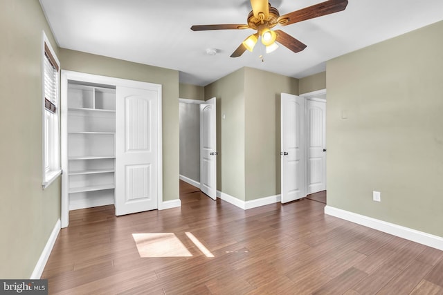 unfurnished bedroom featuring wood finished floors, baseboards, and ceiling fan