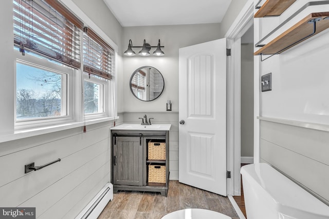 bathroom featuring vanity, a tub to relax in, and wood finished floors