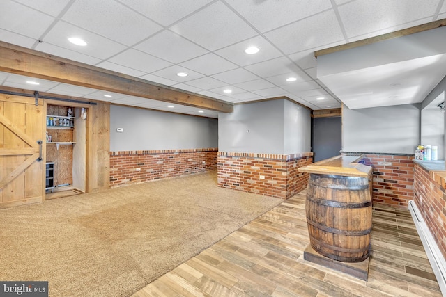 interior space featuring a wainscoted wall, recessed lighting, a paneled ceiling, and a barn door