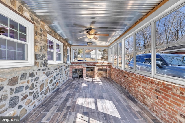 unfurnished sunroom with wood ceiling and ceiling fan