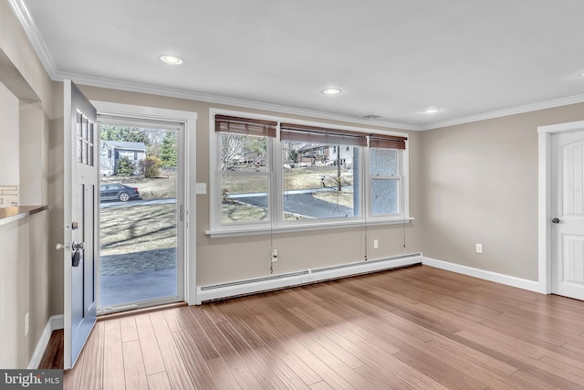 interior space featuring a baseboard heating unit, baseboards, ornamental molding, recessed lighting, and wood finished floors