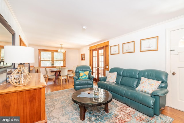 living area with french doors, wood finished floors, and ornamental molding