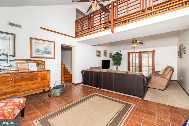 tiled living room with visible vents, baseboards, stairway, high vaulted ceiling, and a ceiling fan