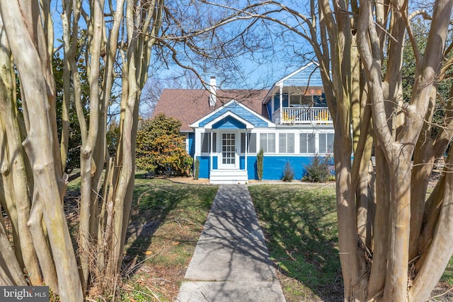 view of front of house with a balcony and roof with shingles