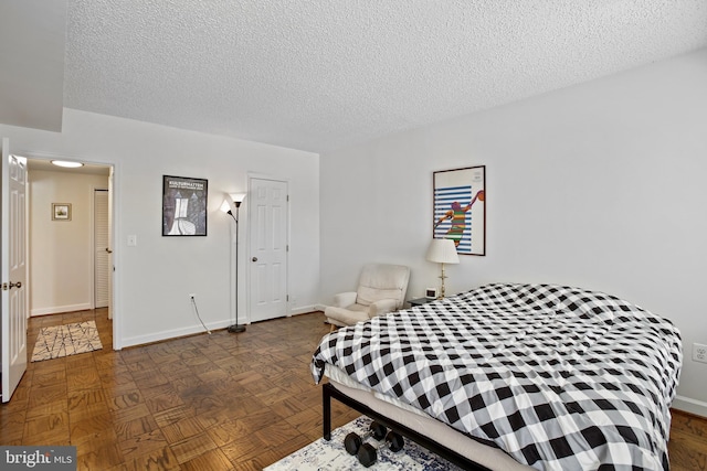 bedroom featuring baseboards and a textured ceiling