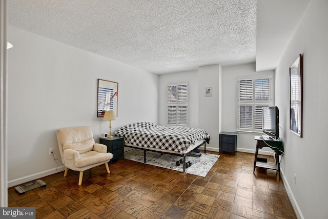 bedroom with a textured ceiling and baseboards