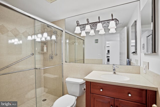 bathroom with vanity, a shower stall, toilet, and visible vents