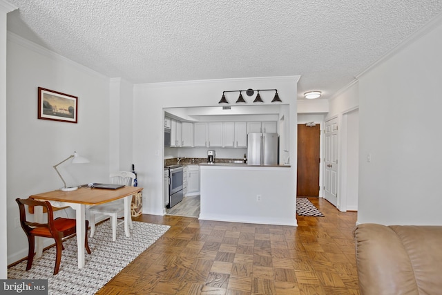 kitchen featuring stainless steel appliances, a textured ceiling, crown molding, and white cabinetry