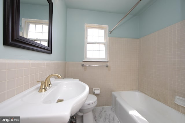 full bath featuring a wainscoted wall, tub / shower combination, a sink, tile walls, and toilet