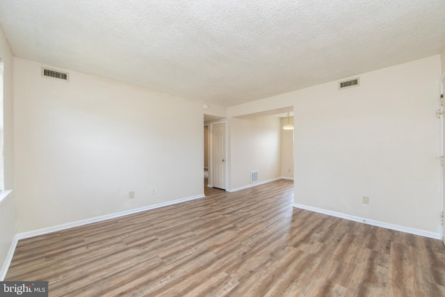 spare room with visible vents, baseboards, and light wood-style floors