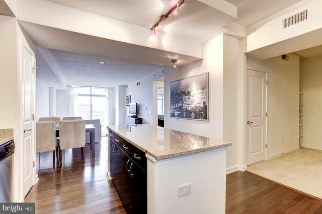 kitchen featuring visible vents, track lighting, light stone countertops, dark wood finished floors, and dishwasher